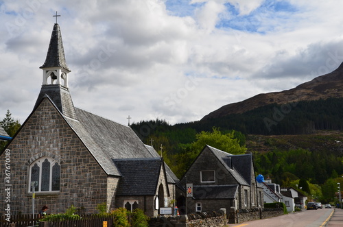 Glencoe street with church set against mountains in the Scottish Highlands.