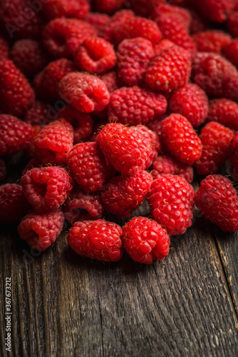 Freshly harvested raspberry on the rustic wooden background. Selective focus. Shallow depth of field.