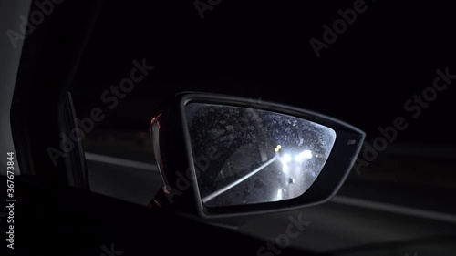 Night shot of car travelling at E94 national highway of Greece, pan from right mirror to dashboard 4K photo