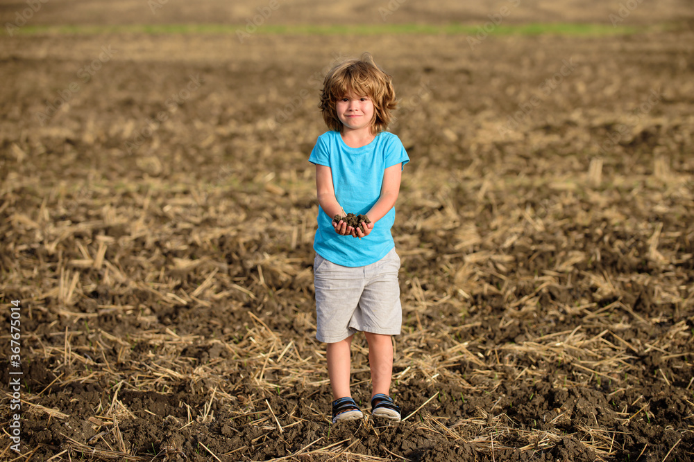 Cute little farmer working on field. Humus soil. Cute little farmer working on field. Humus soil.