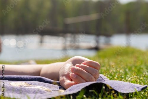 Foto Woman is sunbathing on the lake shore