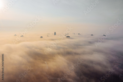 Aerial view of the city in the fog. Skyscrapers above the fog