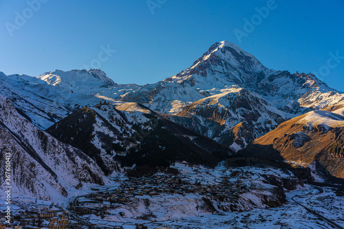 Mountain Kazbegi, a big snow mountain at Caucasus in Georgia, at sunset.