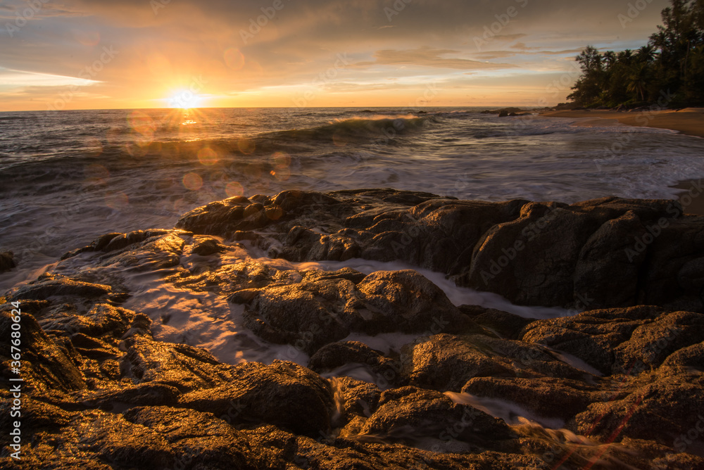 Naklejka premium Silhouette man, Sea sunrise among the rocks. Sea sunrise at thailand 
