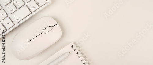 Business concept, workplace, top view. Panoramic banner background with copy space. Office supplies on a white background such as a keyboard, notepad, computer mouse and pen.