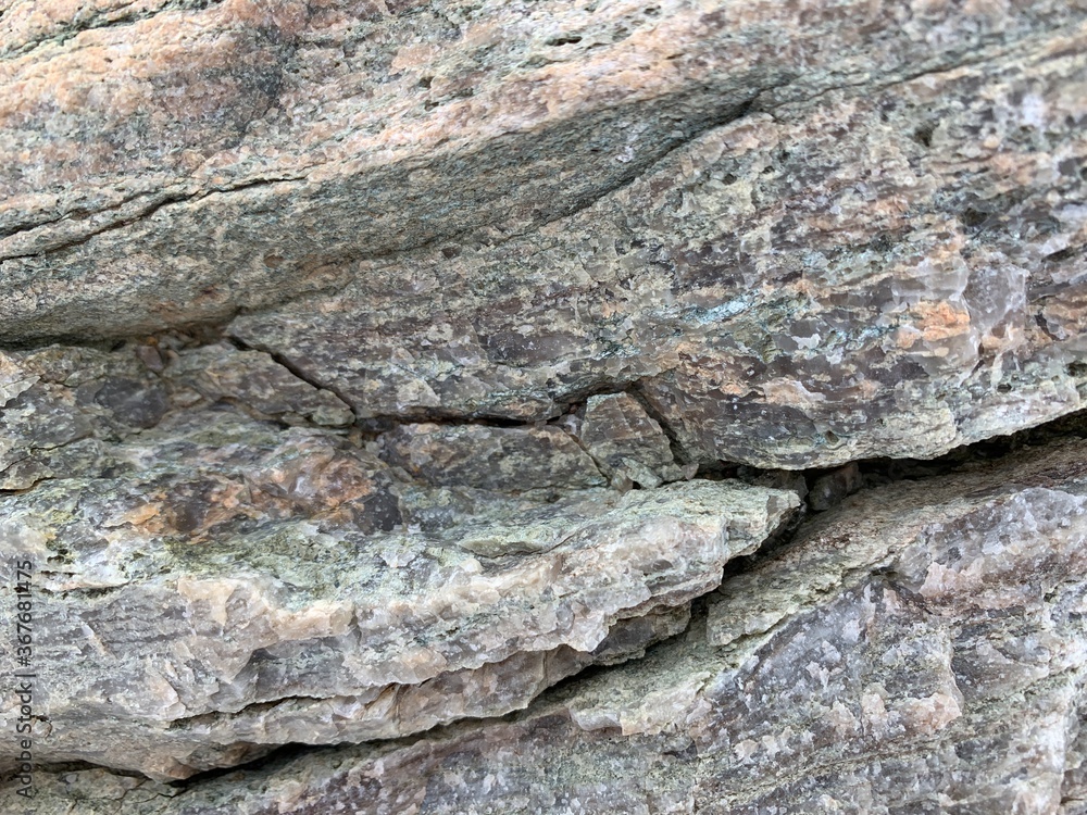 Background texture: the structure of a large stone. Granite boulder close up. Irregularities and cracks in the stone rock. Concept - stone, hardness Background texture: the structure of a large stone. Granite boulder close up. Irregularities and cracks in the stone rock. Concept - stone, hardness
