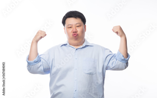 Young Fat Asian business man showing strenght and looking to camera isolated on white background. © Touchr