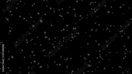 Snow flakes fall down on a black background. A light breeze gives sight.