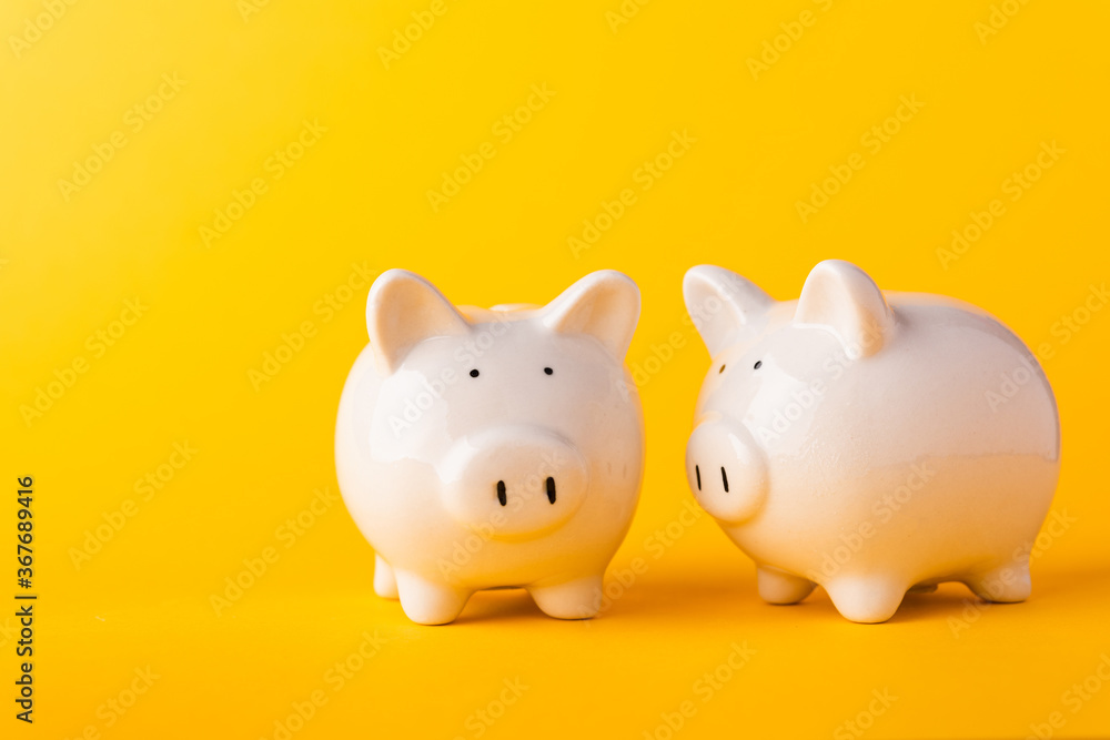 International Friendship Day, Front two small white fat piggy bank, studio shot isolated on yellow background and copy space for use, Finance, deposit saving money concept