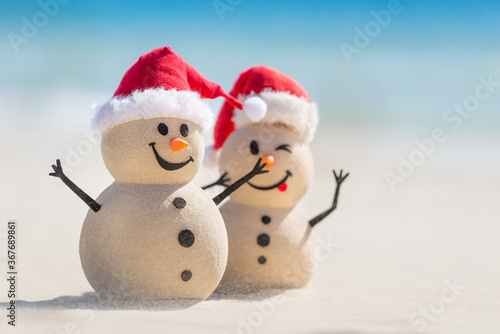 Fotografi Two Sandy Christmas Snowmen are enjoying Christmas holidays on a beautiful beach