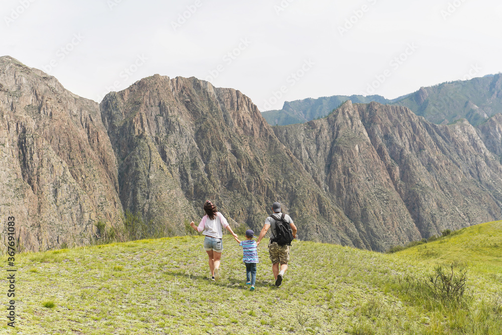 mother, father and child running in the mountains