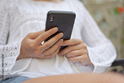 Close up of a young woman writing text messages on her mobile device