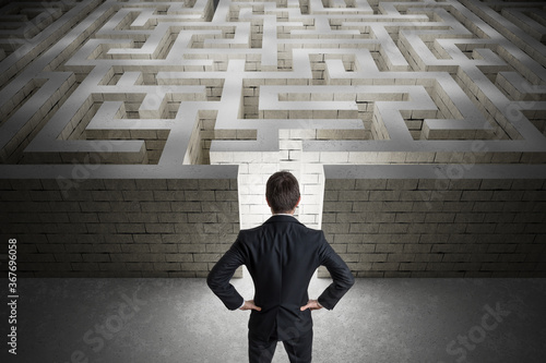 Businessman is searching exit path in maze. Strategy and decision concept.