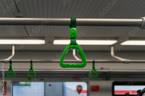 Photography Abstract blurred background of train interior, selective focus of green handles