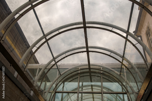 Roof architecture with curved glass for a passageway