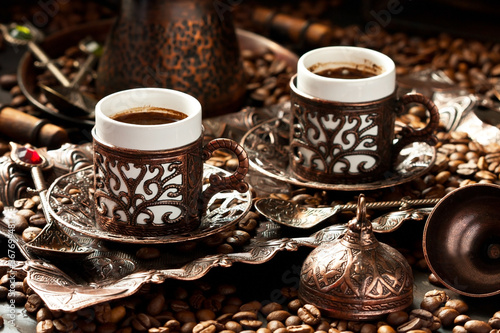 Traditional Turkish coffee served on ornamental copper tray with cups, saucers and lids