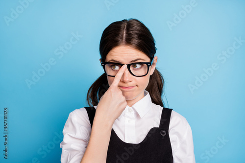 Close-up portrait of her she nice attractive lovely brainy boring dull brunette schoolgirl nerd geek fixing specs learning subject isolated over bright vivid shine vibrant blue color background photo