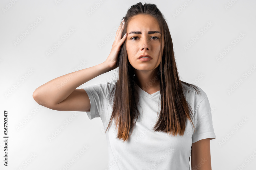 Shocked young woman with long chestnut hair dressed in casual clothes, covering one ear with hand on white background. Keep silence concept Shocked young woman with long chestnut hair dressed in casual clothes, covering one ear with hand on white background. Keep silence concept