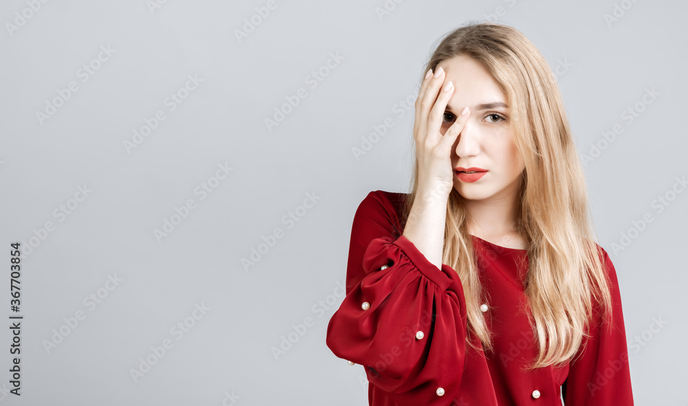 Photo of tired European young woman with long blonde hair, covers face, feels fatigue, needs good rest, has sleepy expression, isolated over gray background. Weariness and people Photo of tired European young woman with long blonde hair, covers face, feels fatigue, needs good rest, has sleepy expression, isolated over gray background. Weariness and people