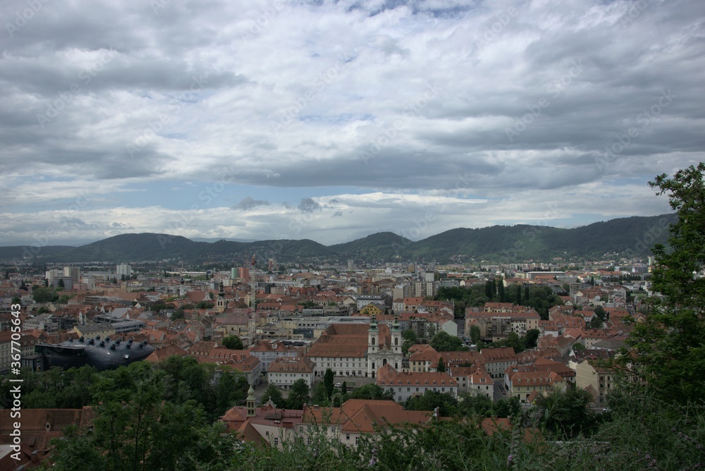 Blick vom Schlossberg über Graz mit dem Kunsthaus an einem bewölkten Tag