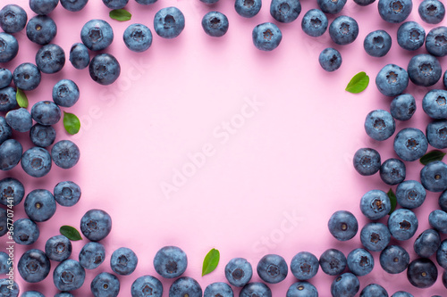 Fruit summer berry background of blueberries on a pink background with place for text, frame.