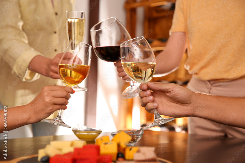 Group of friends toasting with wine at table, closeup Group of friends toasting with wine at table, closeup