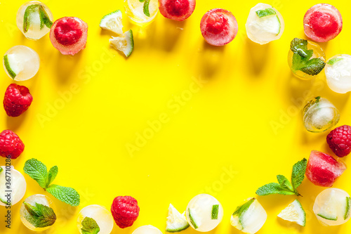 Ice cubes with berries and mint top view frame copy space