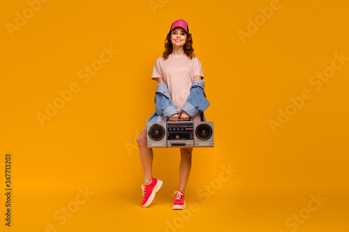 Full length body size view of her she nice attractive lovely fashionable cheerful cheery girl wearing cool look carrying boombox isolated on bright vivid shine vibrant yellow color background