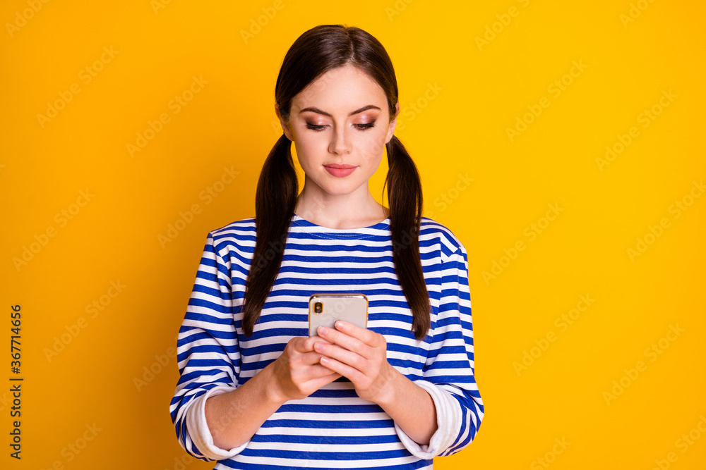 Close-up portrait of her she nice attractive pretty lovely cute focused brown-haired girl using device web service roaming wi-fi connection isolated bright vivid shine vibrant yellow color background Close-up portrait of her she nice attractive pretty lovely cute focused brown-haired girl using device web service roaming wi-fi connection isolated bright vivid shine vibrant yellow color background