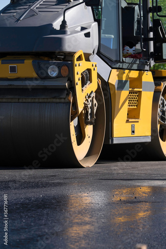 Shovel rolls flat the asphalt on a road in Lemmer. The asphalt is still wet © Henk Vrieselaar