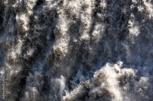 Close-up of Dettifoss, Europe's largest waterfall; sediments give the water a similar gray color as the volcanic rocky surroundings.