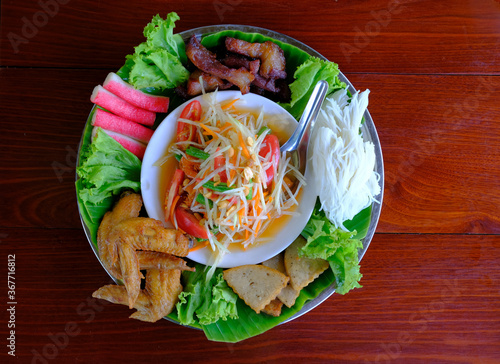 papaya salad or som tum in thai, on tray with side dish set, chicken fried, Rice Noodles, Roasted streaky pork

