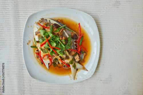 Steamed Butterf fish (SILVER POMFRET)with soy sauce in white dish, top view
