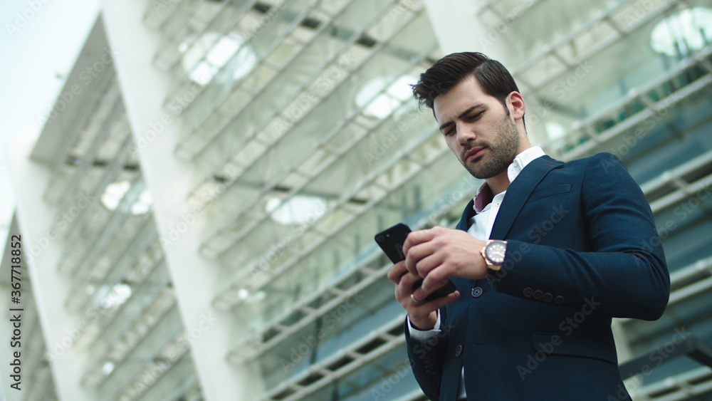 Portrait businessman looking away. Businessman using smartphone outdoors Portrait businessman looking away. Businessman using smartphone outdoors