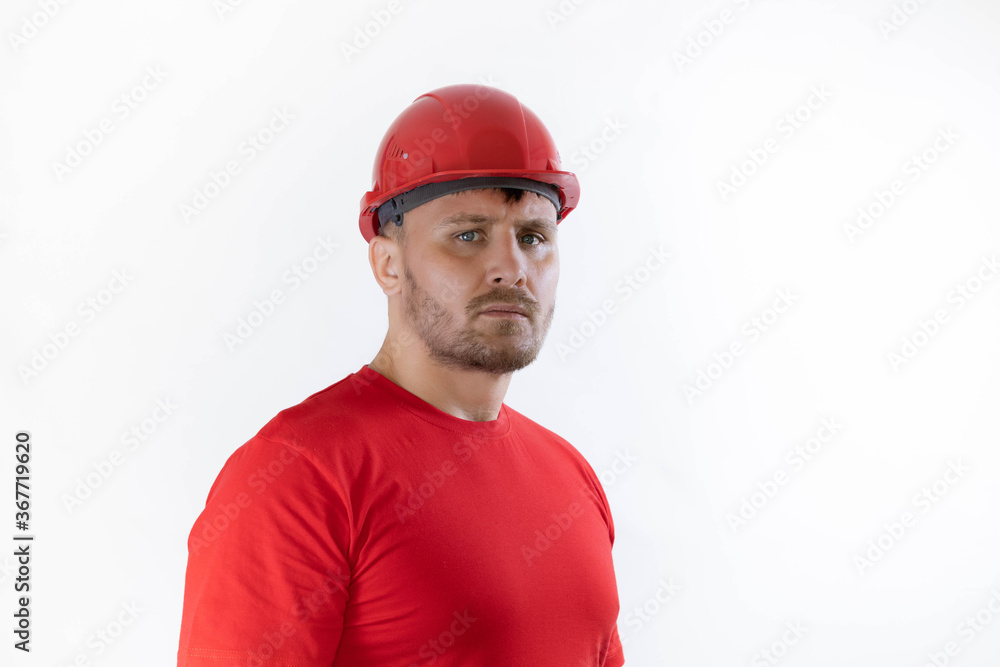 A man in a construction helmet and a red T-shirt. A man in a construction helmet and a red T-shirt.