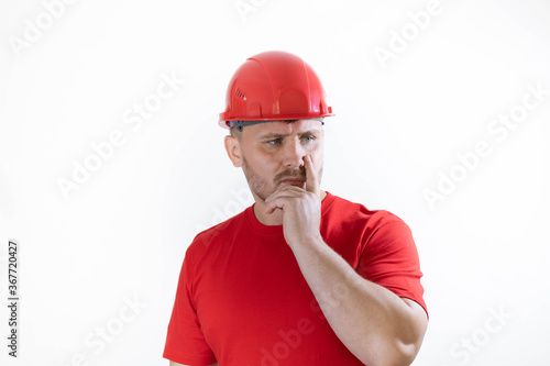 Construction worker in red construction helmet. Builder with a guilty face.