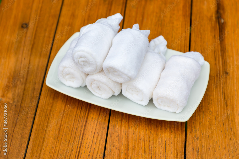Cold towels, welcome in the hotel. Wet welcoming refreshing towels at the eastern restaurant. Welcome, guest, hygiene, tradition concept. Refreshing towel in welcome drink set. Cold towels, welcome in the hotel. Wet welcoming refreshing towels at the eastern restaurant. Welcome, guest, hygiene, tradition concept. Refreshing towel in welcome drink set.