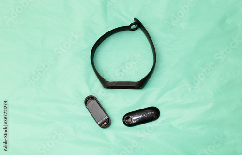 Canvas Print A broken collapsed fitness pedometer bracelet lies on a blue background
