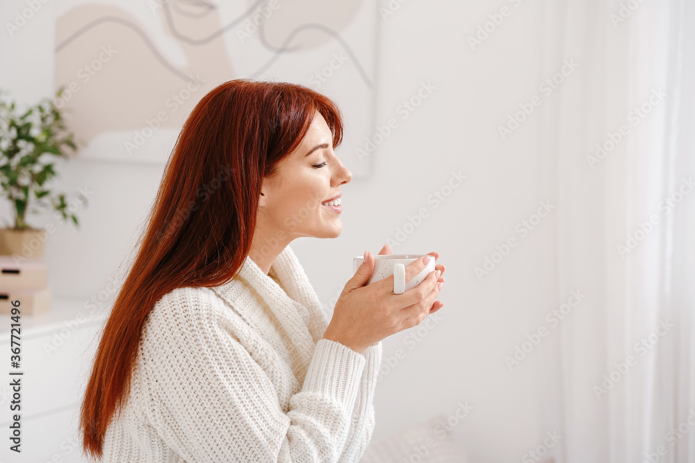 Beautiful redhead woman drinking tea at home Beautiful redhead woman drinking tea at home