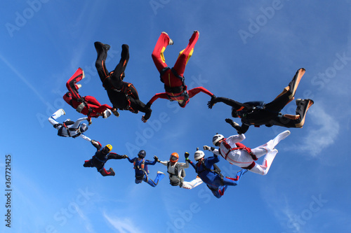 Skydiving. A circle figure of skydivers is in the sky.