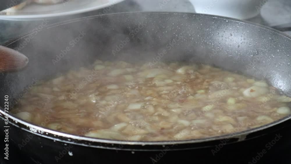 Onion with Broth Boiling in the Frying Pan in order to Make a Sauce for Lunch. Onion with Broth Boiling in the Frying Pan in order to Make a Sauce for Lunch.