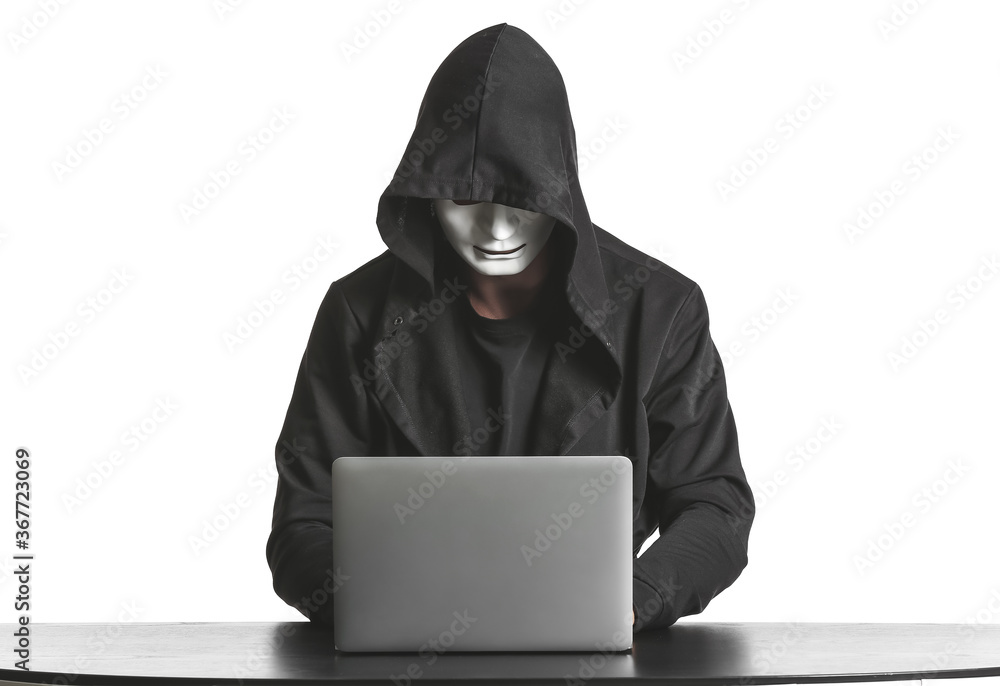 Professional hacker using laptop at table against white background Professional hacker using laptop at table against white background