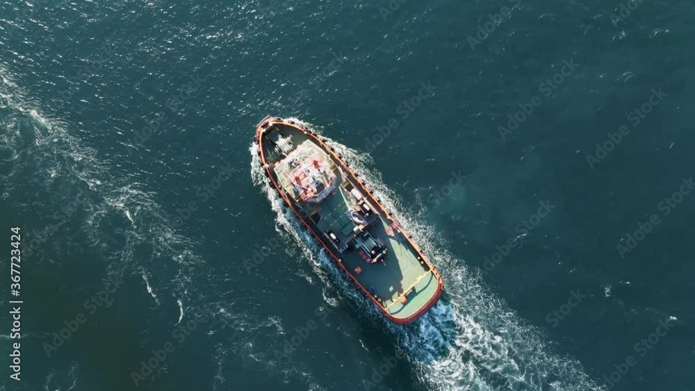 Fishing boat flying drone with large catch fish swirling hungry gulls flock of glaruses aerial view drone. Small ship floats on sea surface leaving a path of sea foam water. Top view. Copy space Fishing boat flying drone with large catch fish swirling hungry gulls flock of glaruses aerial view drone. Small ship floats on sea surface leaving a path of sea foam water. Top view. Copy space