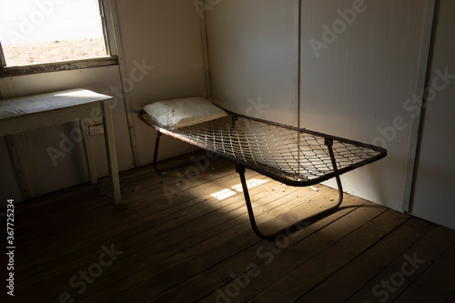 Old wire camp bed in abandoned shearers quarters building. photo