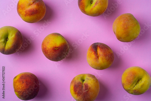 Fresh peaches on a pink background. View from above.