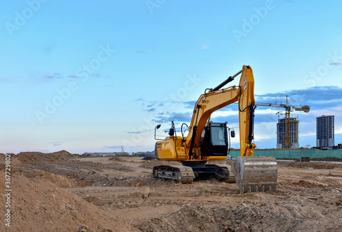 Wallpaper Mural Excavator during road work at construction site. Screeding the gravel for laying asphalt and installing borders and curbs on the new road. Tower crane in action Torontodigital.ca