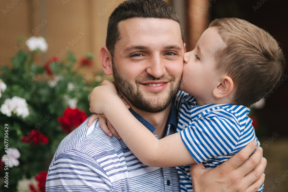 Happy dad with his little sun outdoors. Sun kiss his father cheek Happy dad with his little sun outdoors. Sun kiss his father cheek