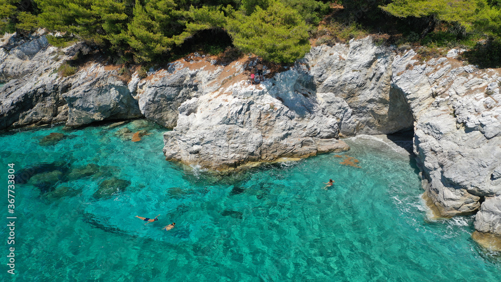 Aerial drone photo of secluded turquoise paradise island rocky cove covered up with pine trees Aerial drone photo of secluded turquoise paradise island rocky cove covered up with pine trees