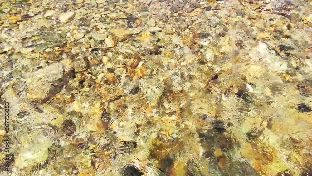 Close-up of the water surface and yellow and broun stones. Pure clean river water is running. 4k video Close-up of the water surface and yellow and broun stones. Pure clean river water is running. 4k video