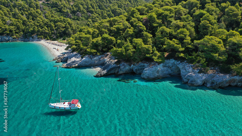 Aerial drone photo of secluded rocky cove near turquoise pebble paradise beach of Kastani covered with pine trees, Skopelos island, Sporades, Greece